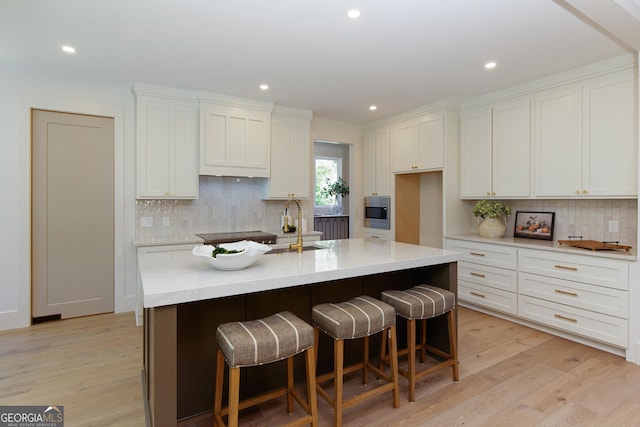 5535 Chestatee Landing Way, Gainesville, GA 30506 - kitchen with stainless steel microwave, backsplash, recessed lighting, white cabinets, and light wood-type flooring