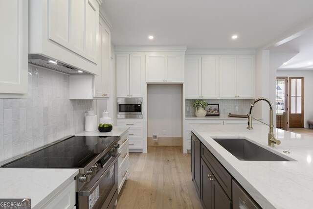 5535 Chestatee Landing Way, Gainesville, GA 30506 - kitchen with appliances with stainless steel finishes, a sink, white cabinets, decorative backsplash, and light stone countertops