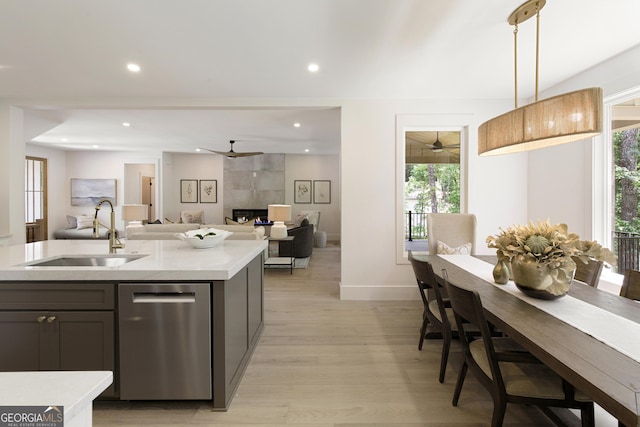 5535 Chestatee Landing Way, Gainesville, GA 30506 - kitchen with a sink, stainless steel dishwasher, a ceiling fan, light countertops, and light wood finished floors