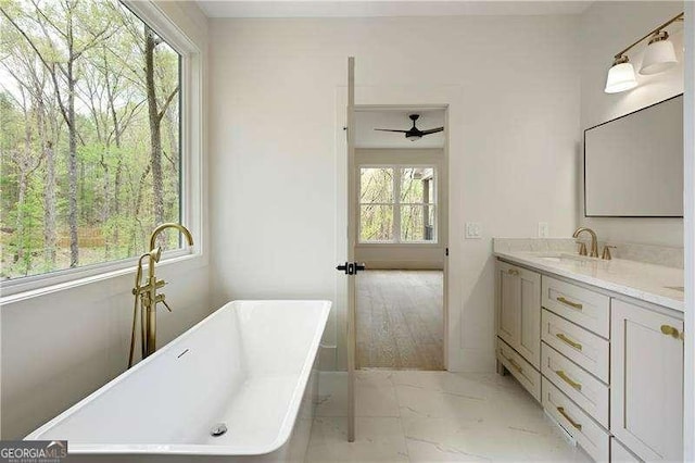 5535 Chestatee Landing Way, Gainesville, GA 30506 - full bathroom featuring marble look tiles, a freestanding bath, vanity, and a ceiling fan