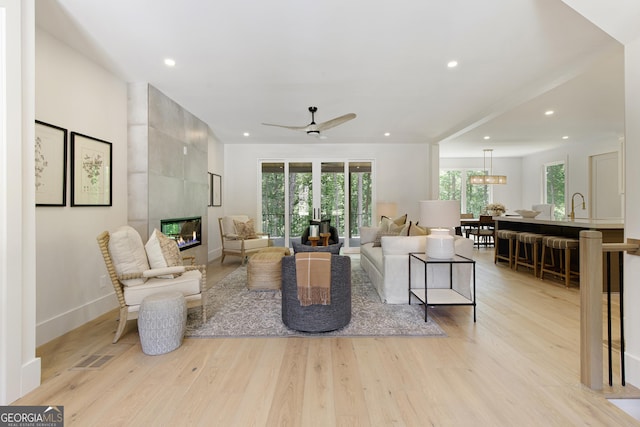 5535 Chestatee Landing Way, Gainesville, GA 30506 - living room featuring a tile fireplace, light wood-style flooring, recessed lighting, a ceiling fan, and baseboards