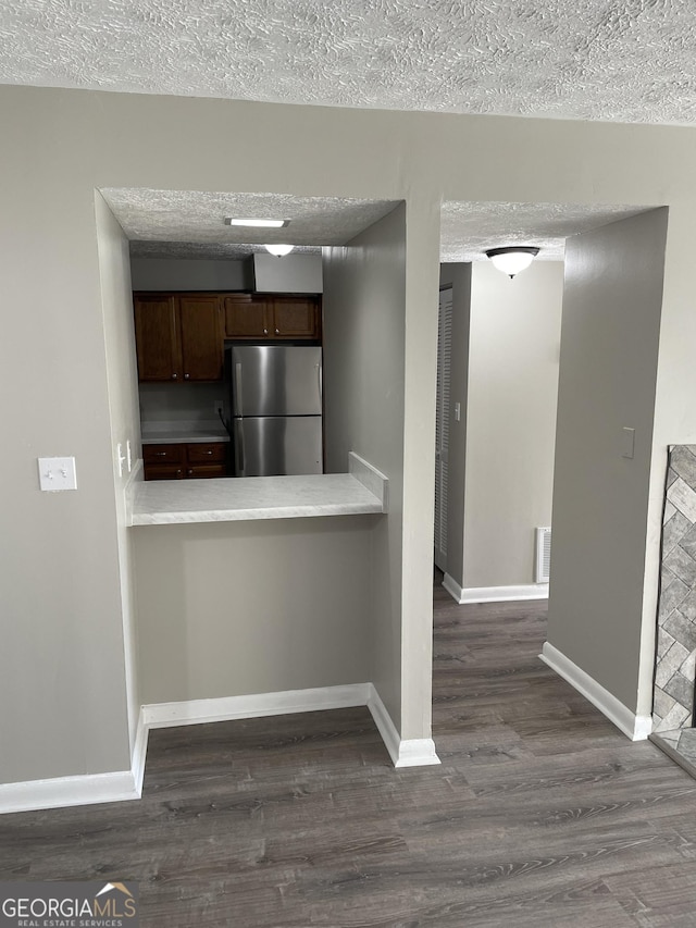 3621 Stedman Pl, Duluth, GA 30096 - kitchen featuring freestanding refrigerator, dark wood finished floors, light countertops, dark brown cabinetry, and a textured ceiling