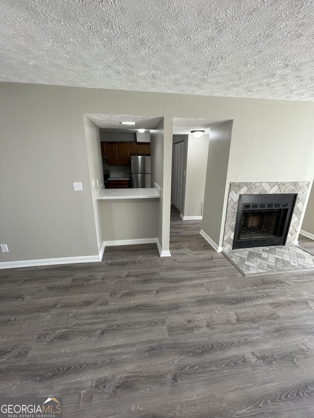 3621 Stedman Pl, Duluth, GA 30096 - unfurnished living room featuring dark wood-type flooring, a textured ceiling, and a fireplace