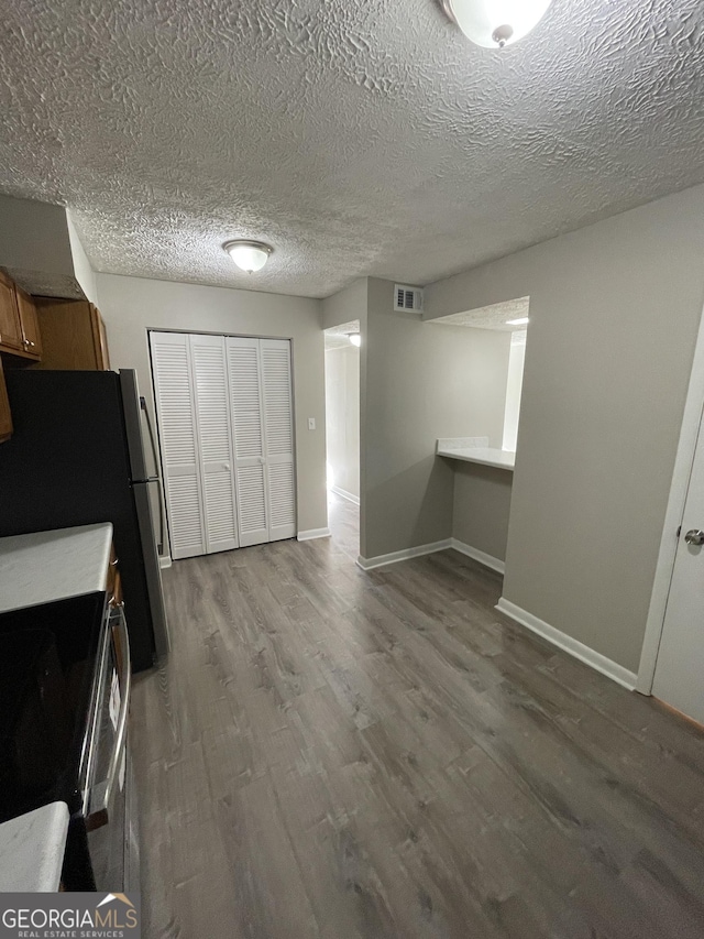 3621 Stedman Pl, Duluth, GA 30096 - kitchen with wood finished floors, electric stove, brown cabinets, a textured ceiling, and freestanding refrigerator