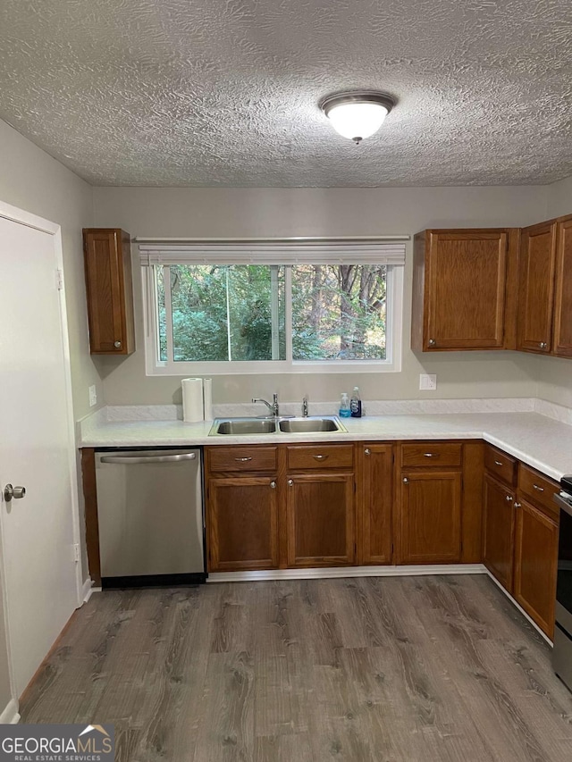 3621 Stedman Pl, Duluth, GA 30096 - kitchen with appliances with stainless steel finishes, dark wood-style flooring, brown cabinetry, a textured ceiling, and plenty of natural light