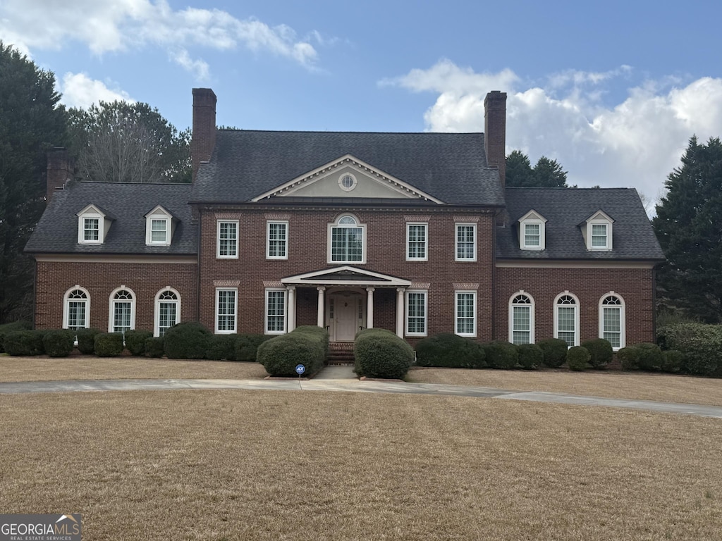 1621 Maple Dr, Griffin, GA 30224 - georgian-style home with a chimney and brick siding