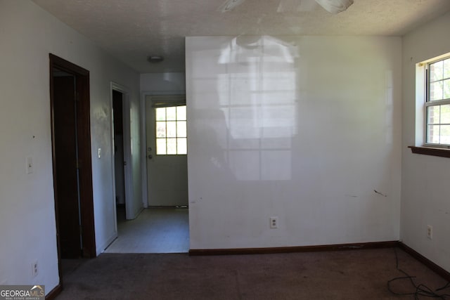 carpeted spare room with baseboards and a textured ceiling