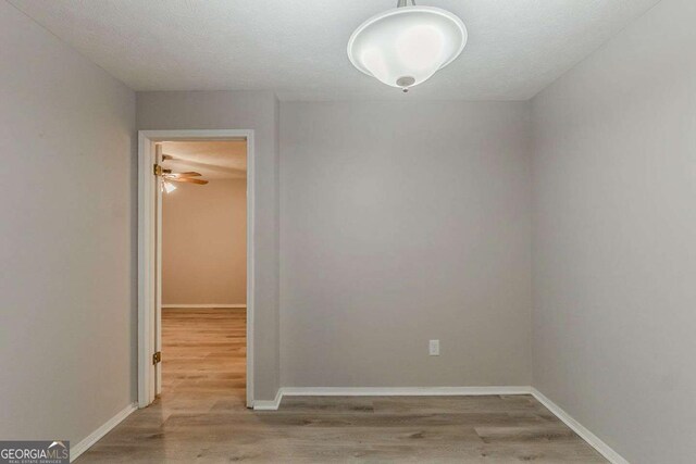 spare room featuring baseboards and wood finished floors