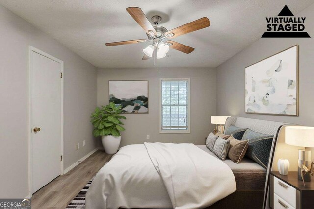 bedroom featuring light wood-style floors, baseboards, and a ceiling fan