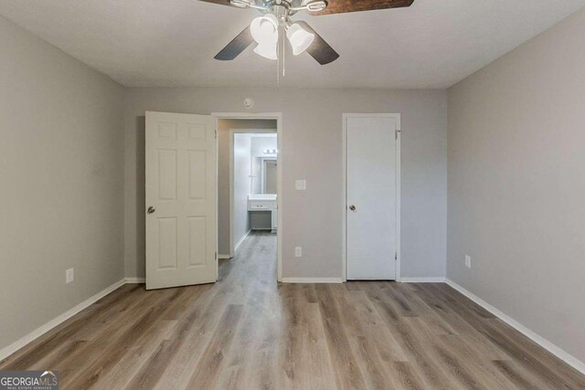 unfurnished bedroom featuring baseboards, light wood-type flooring, and a ceiling fan