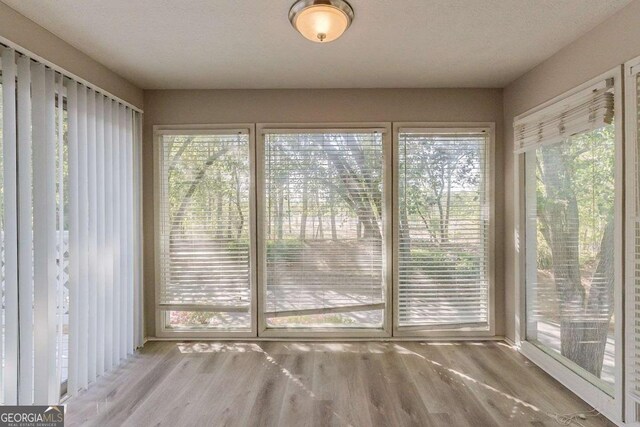 unfurnished sunroom featuring wood finished floors