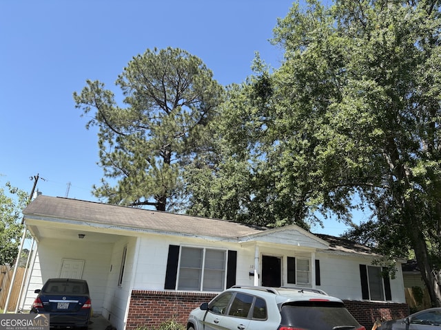 view of front of home featuring brick siding and an attached carport