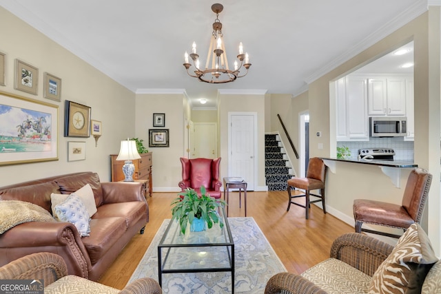 living room featuring light wood-style floors, ornamental molding, a chandelier, stairs, and baseboards