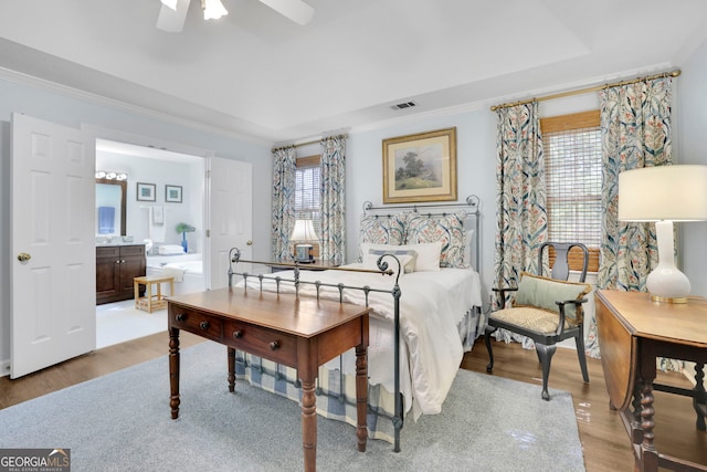 bedroom with light wood-type flooring, crown molding, multiple windows, and visible vents