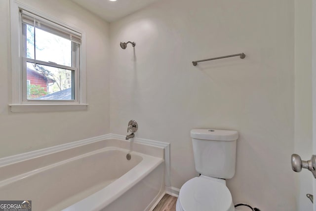 5350 Rockbridge Rd, Stone Mountain, GA 30088 - bathroom featuring baseboards, toilet, and a washtub