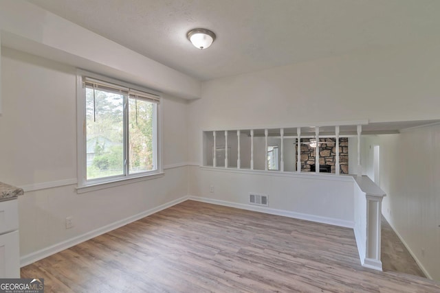 5350 Rockbridge Rd, Stone Mountain, GA 30088 - unfurnished room with visible vents, baseboards, wood finished floors, and a fireplace