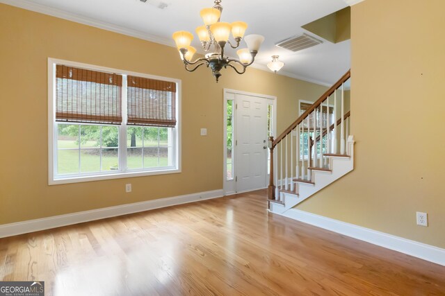 532 Zellner Rd, Forsyth, GA 31029 - foyer entrance featuring a chandelier, crown molding, baseboards, wood finished floors, and stairs