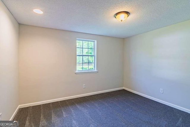 unfurnished room featuring baseboards, recessed lighting, a textured ceiling, and dark carpet