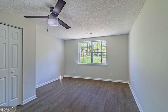 unfurnished bedroom featuring ceiling fan, a textured ceiling, a closet, visible vents, and wood finished floors