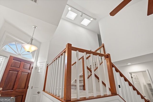 entryway featuring track lighting, a high ceiling, and stairway