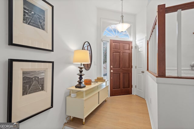 entryway with light wood-style flooring and baseboards