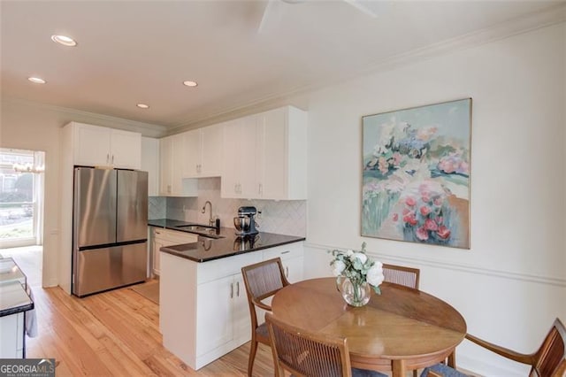 1038 Huntcliff, Atlanta, GA 30350 - kitchen featuring white cabinets, a sink, dark countertops, freestanding refrigerator, and a peninsula
