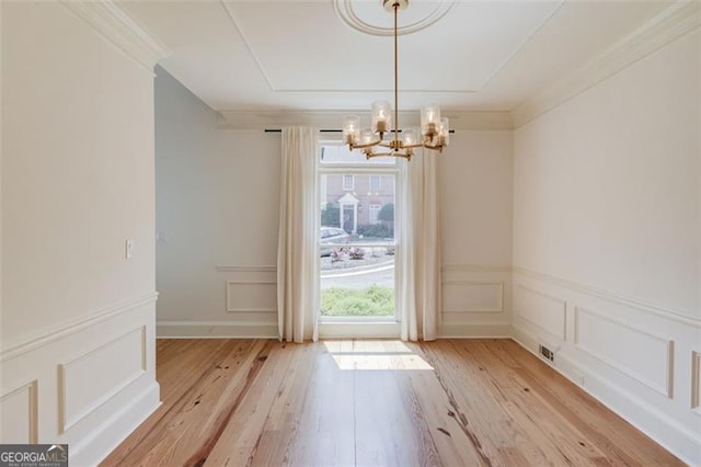 1038 Huntcliff, Atlanta, GA 30350 - unfurnished dining area with a chandelier, a decorative wall, light wood finished floors, and ornamental molding