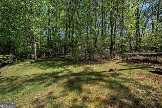 view of yard featuring fence and a trampoline