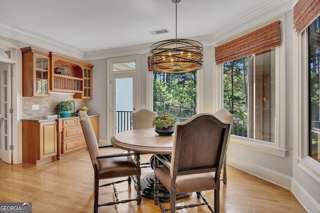 dining area featuring baseboards, a notable chandelier, visible vents, and a wealth of natural light