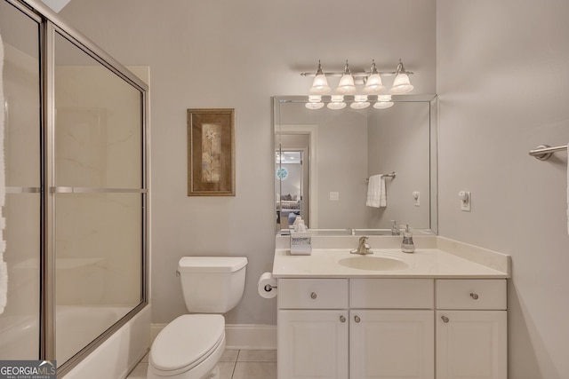 bathroom with shower / bath combination with glass door, vanity, baseboards, tile patterned flooring, and toilet