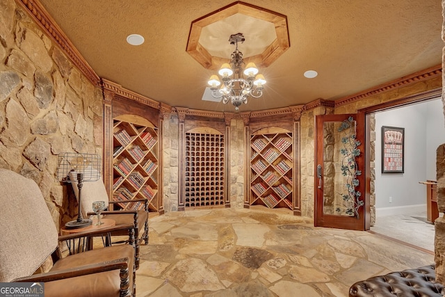 wine area with recessed lighting, a notable chandelier, a textured ceiling, and stone flooring