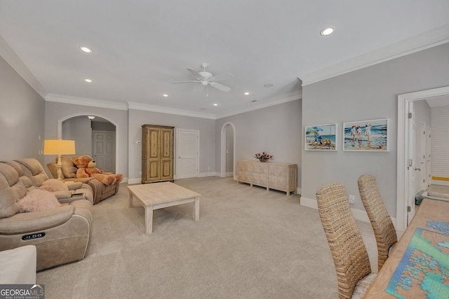living room with arched walkways, light colored carpet, a ceiling fan, recessed lighting, and baseboards