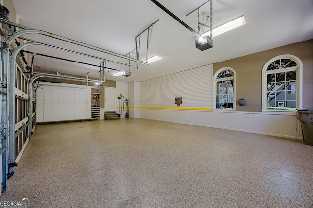 garage with a wainscoted wall and a garage door opener
