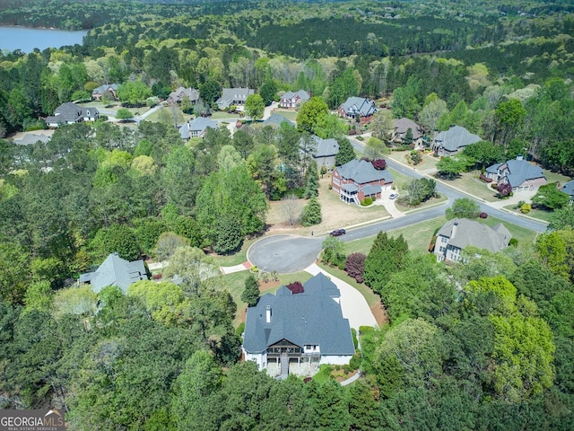 birds eye view of property featuring a wooded view, a residential view, and a water view