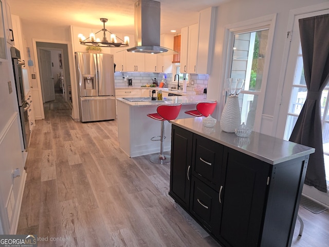3650 Bay Leaf Dr, Loganville, GA 30052 - kitchen with stainless steel refrigerator with ice dispenser, island exhaust hood, dark cabinets, a chandelier, and light countertops