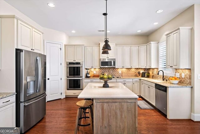 2358 New Salem Trce, Marietta, GA 30064 - kitchen with appliances with stainless steel finishes, a sink, decorative backsplash, a kitchen bar, and decorative light fixtures