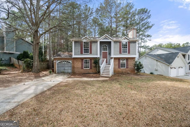 5275 Forest Downs Cir, Atlanta, GA 30349 - bi-level home featuring concrete driveway, a chimney, brick siding, a garage, and fence