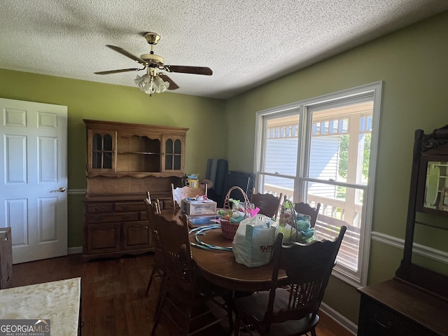 dining space with baseboards, dark wood-style flooring, a textured ceiling, and a ceiling fan