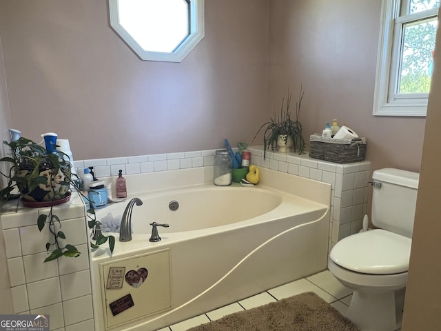 bathroom with tile patterned flooring, a bath, and toilet