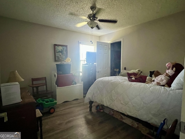 bedroom featuring a textured ceiling, wood finished floors, and a ceiling fan