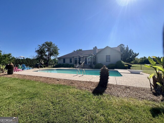 view of swimming pool featuring a yard, a patio area, a fenced in pool, and fence