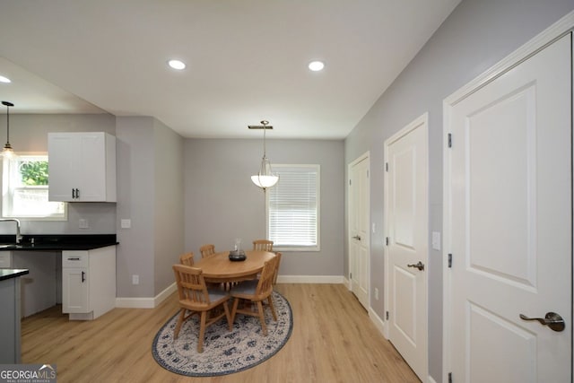 dining room featuring a wealth of natural light, light wood finished floors, and baseboards