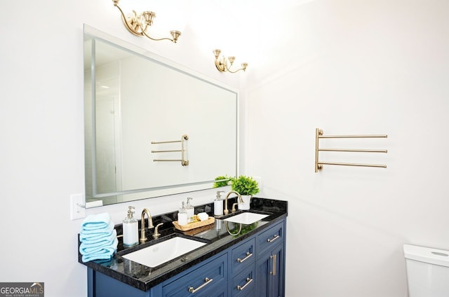 bathroom featuring a sink, double vanity, and toilet