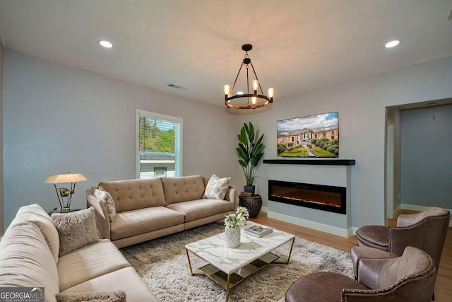 living area with baseboards, a chandelier, wood finished floors, and recessed lighting
