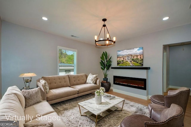 living area with recessed lighting, wood finished floors, visible vents, baseboards, and a notable chandelier