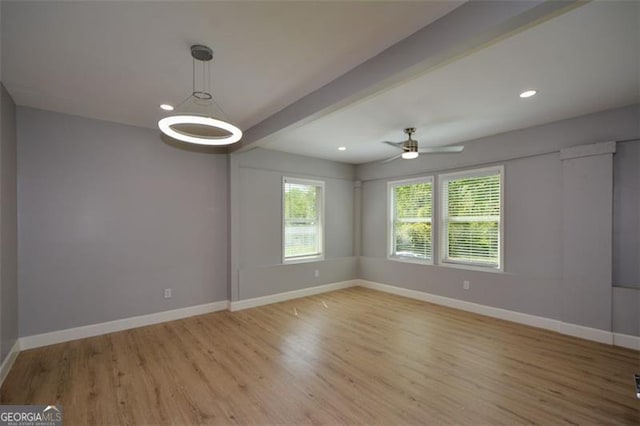 unfurnished room with ceiling fan, baseboards, beamed ceiling, and light wood finished floors
