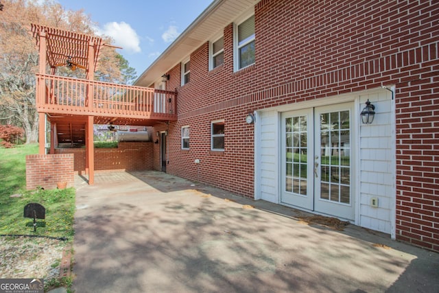 back of house with brick siding, french doors, and a wooden deck