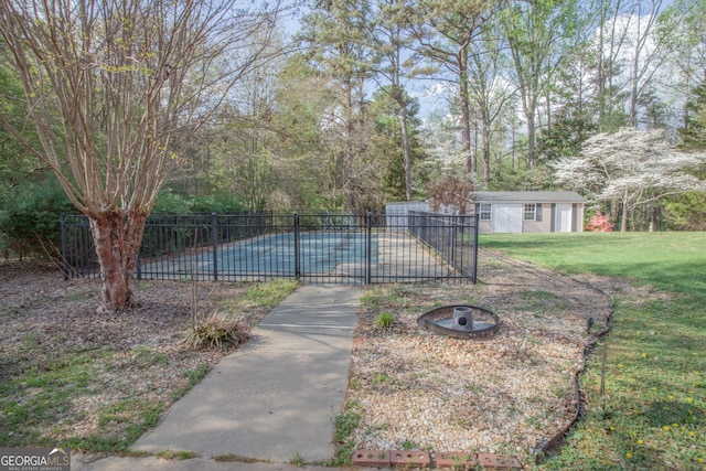 view of swimming pool with an outbuilding, a fenced in pool, fence, and a lawn