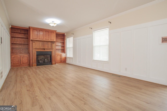 724 Ga Highway 120, Tallapoosa, GA 30176 - unfurnished living room featuring a decorative wall, a fireplace, crown molding, light wood-style flooring, and wainscoting