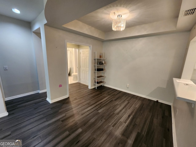 220 Renaissance Pkwy NE Apt 2220, Atlanta, GA 30308 - spare room featuring baseboards, a raised ceiling, dark wood-style flooring, and a chandelier